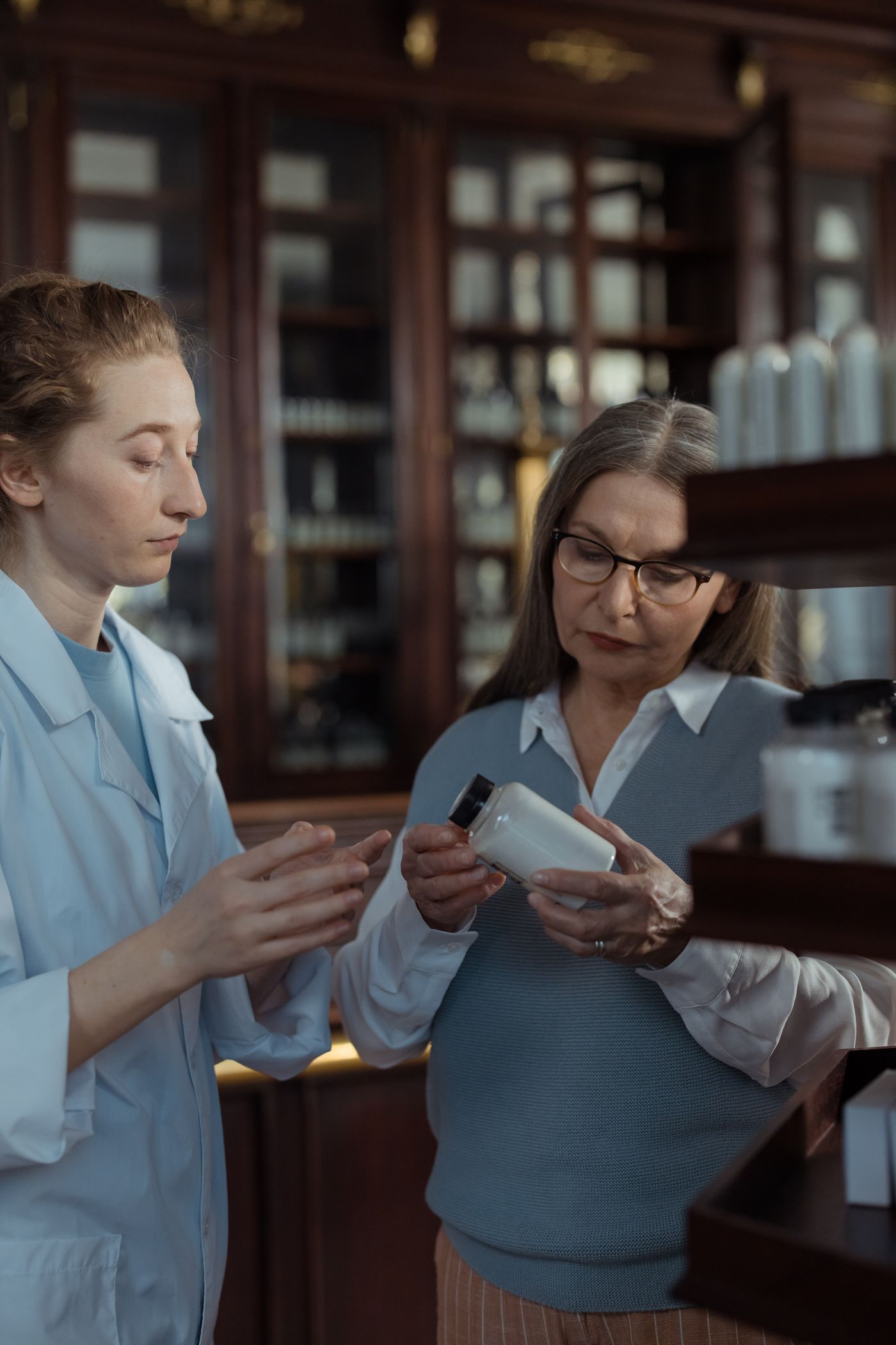 Profesional de parafarmacia asesorando a una clienta sobre un producto
